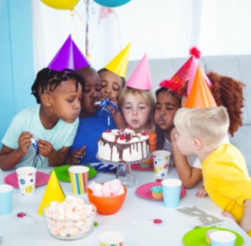 kids blowing a cake